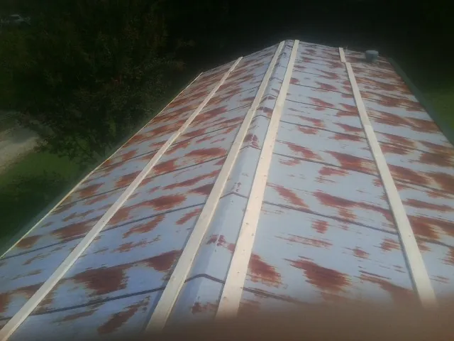 Rusted metal roof panels with new wood purlins before replacement — Storm Damage Roof Repair in Sargeant by Roofing Brothers